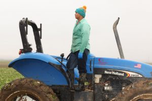 worker standing on a tractor